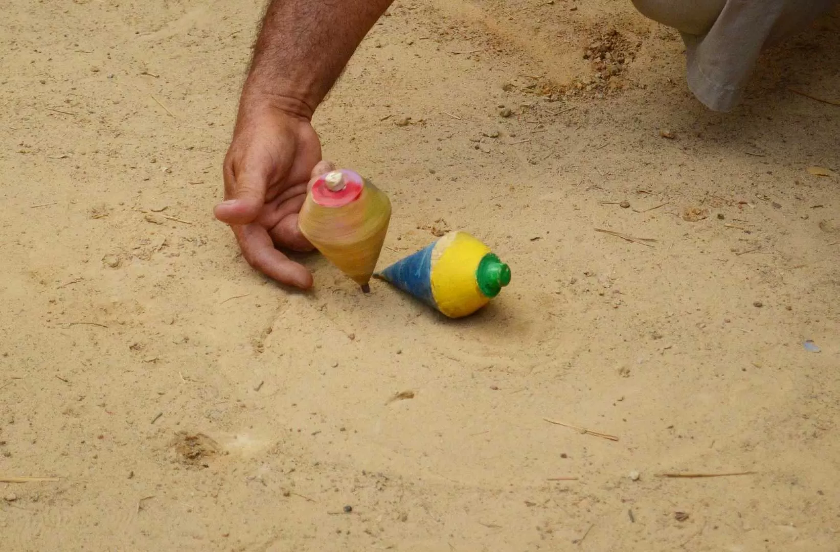 El juego de la troya donde niños, jovenes y adultos compiten por meter primero un trompo dentro de la troya.
